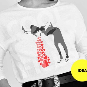 Peut inclure: Un t-shirt blanc à manches longues avec un imprimé graphique d'une personne vomissant des cœurs. Le graphique est en noir et blanc, avec les cœurs en rouge.