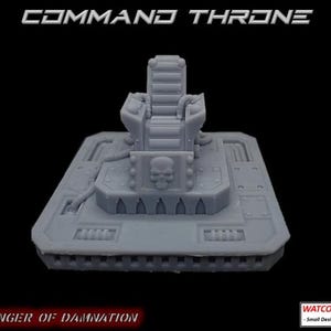 May include: A grey miniature command throne featuring a high-backed seat with ribbed detailing, mounted on a square platform with mechanical floor textures and a prominent skull emblem on the front. The text COMMAND THRONE and HARBINGER OF DAMNATION appear in the image.
