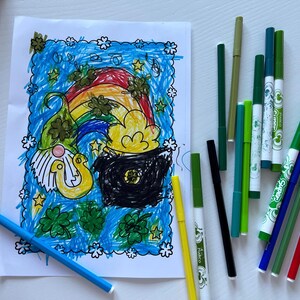 May include: A coloring page featuring a leprechaun, a pot of gold, and a rainbow. The page is surrounded by green shamrocks and stars. There are several green, blue, red, and black markers on a white surface.