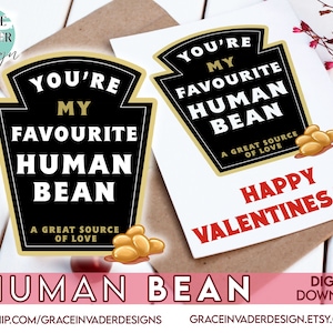 Puede incluir: Una tarjeta de San Valentín con un diseño negro y dorado que dice "Eres mi frijol humano favorito. Una gran fuente de amor." La tarjeta también tiene un mensaje rojo y blanco "Feliz Día de San Valentín".