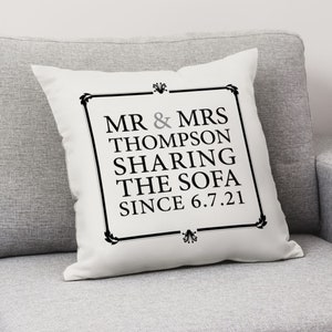 May include: White cushion with black text that reads "Mr. & Mrs. Thompson Sharing The Sofa Since 6.7.21".