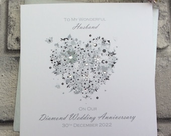 Może przedstawiać: Biała kartka z srebrnym wzorem serca i tekstem "To My Wonderful Husband On Our Diamond Wedding Anniversary 30th December 2022".