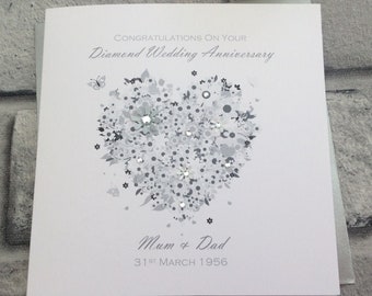 May include: A white card with a silver heart design and the text "Congratulations on your Diamond Wedding Anniversary" and "Mum & Dad 31st March 1956".