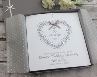 May include: A white card with a silver heart design and the text "60 Wonderful Years" inside the heart. The card also says "Congratulations on your Diamond Wedding Anniversary Mum & Dad 20th March 2021".
