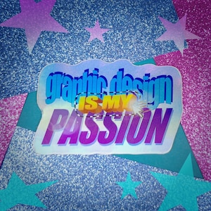Puede incluir: Una pegatina holográfica con el texto "graphic design IS MY PASSION" en azul y morado. La pegatina está sobre un fondo de purpurina azul y rosa con recortes en forma de estrella.