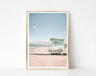 May include: A framed photograph of a light blue lifeguard stand on a sandy beach with a wooden walkway leading up to it. The sky is a pale blue with a few white clouds. The text "PHOTO DESIGN BY ALECIA" is printed in the lower left corner of the image.