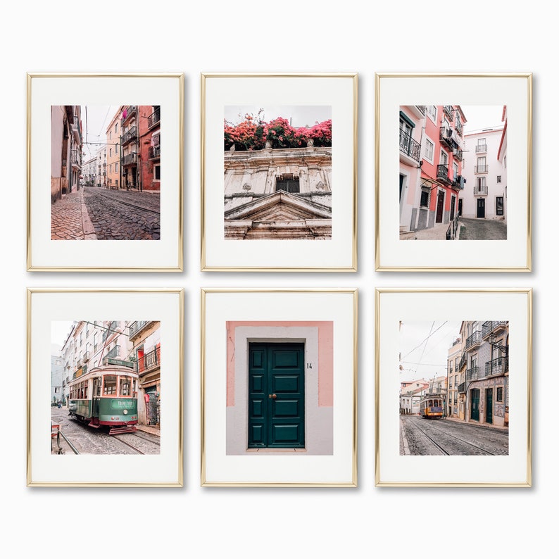 May include: A set of six framed photographs showcasing different scenes from Lisbon, Portugal. The photos include a street lined with colourful buildings, a close-up of a building facade with pink flowers, a green door with a pink and white wall, a tram travelling down a street, and two more street scenes.