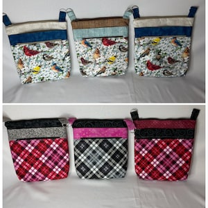 May include: Six fabric pouches with different patterns and colors. The pouches have a top zipper closure and a handle. The patterns include birds, plaid, and swirls.