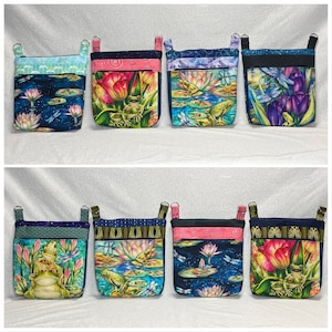 May include: Eight fabric pouches with zipper closures and hanging loops. The pouches feature a variety of colorful floral and frog designs.