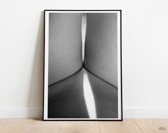 Peut inclure: Photographie en noir et blanc des jambes d'une personne, avec une source de lumière intense créant une ligne brillante au centre de l'image.