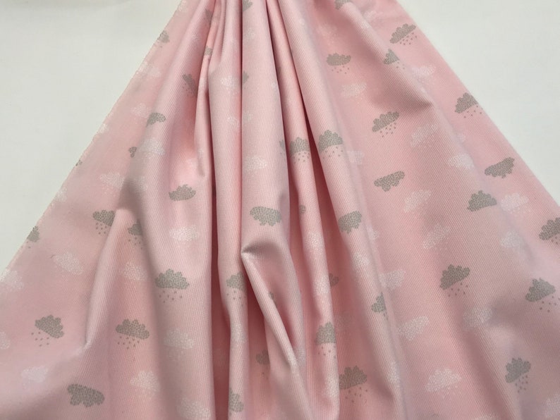 May include: Pink fabric with a white and gray cloud pattern. The clouds have raindrops falling from them.