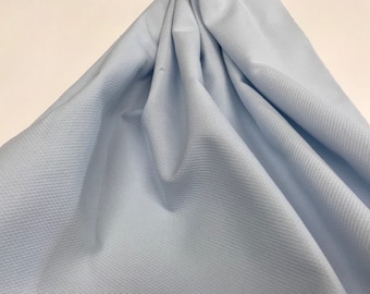 May include: A light blue waffle weave fabric with a textured surface.