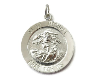 May include: Silver Saint Michael pendant with the words "Saint Michael Pray For Us" around the edge.