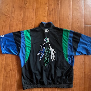 May include: Black, blue, and green vintage Starter basketball jacket. The jacket features a basketball graphic with three figures reaching for the ball. The jacket has a zipper closure and elastic cuffs. The Starter logo is visible on the collar.