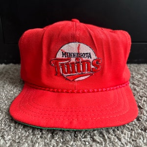 May include: Red baseball cap with a white and red embroidered Minnesota Twins logo. The logo features a baseball and the team name.