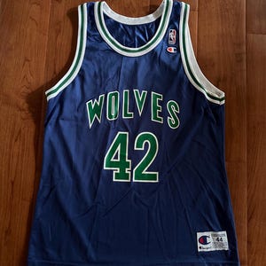 May include: A navy blue Champion basketball vest with the word "WOLVES" in white and green lettering across the chest, and the number "42" in green. The vest has white and green trim around the neck and armholes.