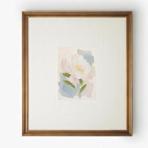 May include: A framed painting featuring an abstract floral subject with thick, textured brushstrokes in shades of white, soft pink, pale yellow, and muted blue, set within a wide off-white mat and a metallic gold-toned rectangular frame.