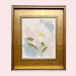 May include: An oil painting on canvas featuring an abstract floral motif in soft pastel shades of pink, white, yellow, and sage green, set within a wide, ornate gold-toned frame with a smooth, reflective finish and a rectangular border design.