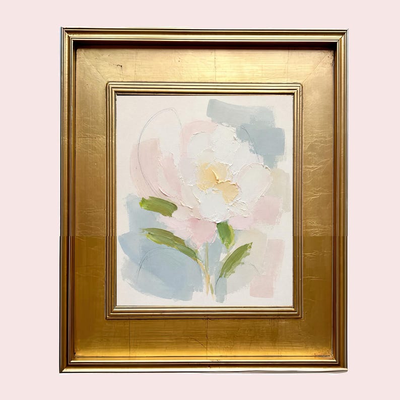 May include: An oil painting on canvas featuring an abstract floral motif in soft pastel shades of pink, white, yellow, and sage green, set within a wide, ornate gold-toned frame with a smooth, reflective finish and a rectangular border design.