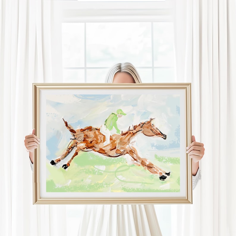 A person holds up a framed impressionist horse painting in front of a white window with sheer curtains.