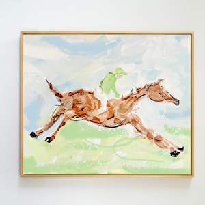 May include: An impressionistic painting in a gold frame depicting a brown horse galloping across a light green field. A rider wearing a bright lime green top and white pants sits atop the horse. The background features soft blue and white sky.