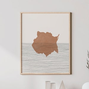 Peut inclure: Un intérieur de salon minimaliste avec une console en bois dotée d'une porte en rotin tissé et d'étagères. Une impression abstraite encadrée avec une forme brune et des lignes blanches est accrochée au mur au-dessus de la console. Un vase blanc avec des branches séchées est posé sur la table.