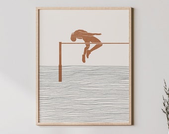 Peut inclure: Une impression d'art minimaliste représentant une silhouette brune d'une personne sautant par-dessus une barre, sur un fond de lignes grises. L'impression est encadrée dans un cadre en bois clair et est accrochée à un mur blanc au-dessus d'un meuble en bois.