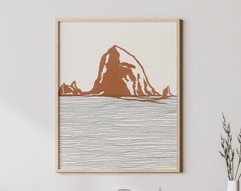 Puede incluir: Una impresión artística enmarcada que presenta un paisaje minimalista con una silueta de montaña marrón sobre un mar gris texturizado. La obra de arte se muestra en un marco de madera clara, que complementa los muebles de madera natural. Un jarrón blanco con hierba alta se encuentra sobre un mueble de madera.