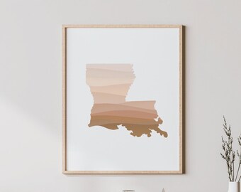 Puede incluir: Una impresión enmarcada del estado de Luisiana, con un degradado de colores marrón y beige. La impresión está sobre un fondo blanco y tiene un marco de madera claro.