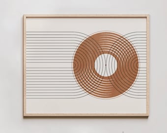 May include: A framed print with a geometric design of overlapping circles in shades of brown and white on a cream background. The print is hanging on a white wall above a wooden shelf with a white vase and dried flowers.
