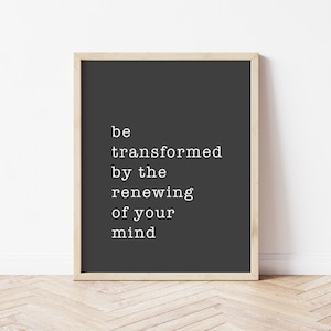 Pode incluir: Uma impressão emoldurada com fundo preto e texto branco que diz "be transformed by the renewing of your mind".