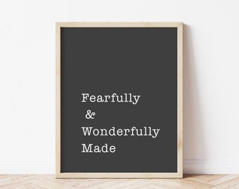 Puede incluir: Una impresión en blanco y negro enmarcada con el texto "Fearfully & Wonderfully Made" sobre un fondo gris oscuro.