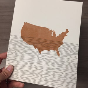 May include: A brown outline of the United States of America on a white background with black wavy lines.