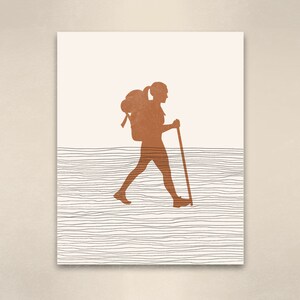 May include: A digital illustration of a person hiking with a backpack and a walking stick. The person is a silhouette in a burnt orange color, walking on a path represented by thin black lines.