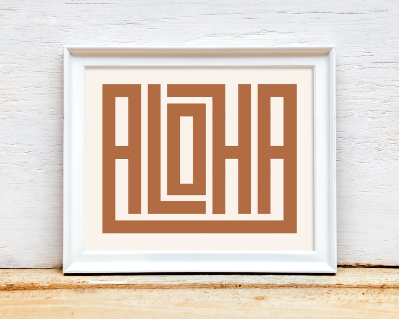 K&ouml;nnte beinhalten: Ein wei&szlig;er gerahmter Druck mit einem braunen geometrischen Design, das das Wort "ALOHA" buchstabiert.