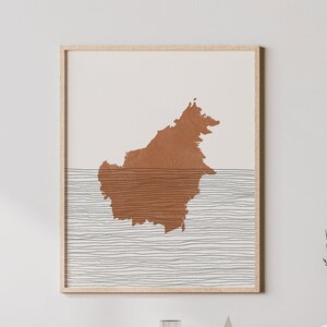 May include: A framed print of a brown outline of an island with a series of thin black lines representing water.