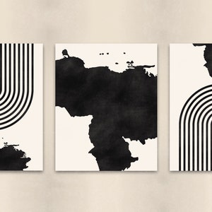 May include: Set of three black and white abstract art prints. Each print features a black and white geometric design with a black watercolor shape in the background.