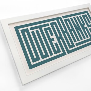 May include: A white framed print with the word "OUTER BANKS" in teal blue, stylized with a geometric pattern.