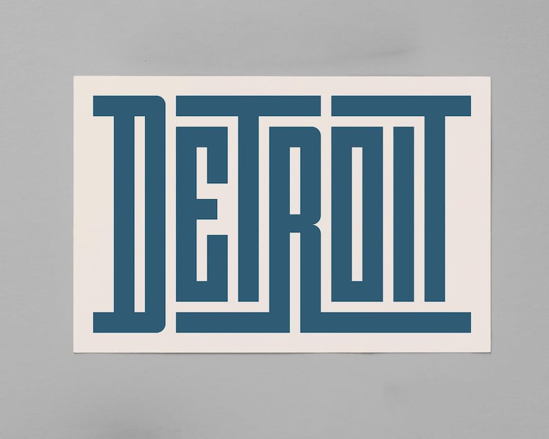 May include: A white background with the word "DETROIT" in blue, stylized with a geometric design.