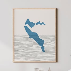 May include: A framed print of a blue abstract island shape with black lines resembling water. The print is on a white background and has a light wood frame.