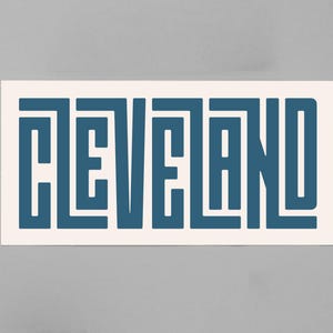 May include: A white sticker with the word "CLEVELAND" written in a blue, geometric font.