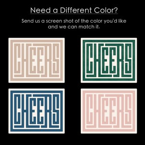 May include: Four square coasters with the word "CHEERS" written in a maze-like pattern. The coasters are in four different colors: beige, green, blue, and pink.