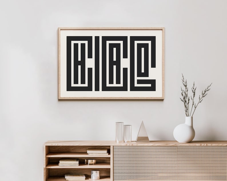 Puede incluir: Una impresi&oacute;n geom&eacute;trica en blanco y negro enmarcada con la palabra "H.I.A.C.O." en una fuente estilizada. La impresi&oacute;n est&aacute; colgada en una pared blanca sobre un estante de madera con un jarr&oacute;n de flores secas y dos cilindros de vidrio transparentes.