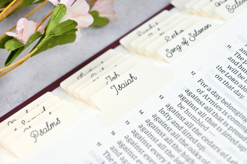 May include: Close-up of a Bible with index tabs for different books, including Psalms, Isaiah, Esther, and Song of Solomon.