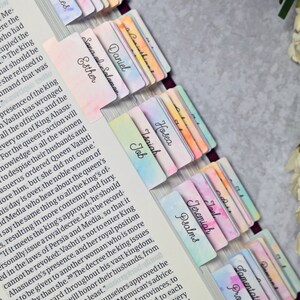May include: A close-up of a Bible with colourful bookmarks for each book of the Bible. The bookmarks are watercolour painted with a variety of colours and designs.