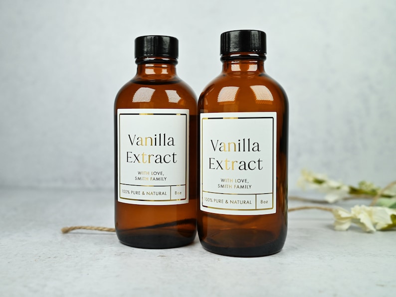 Puede incluir: Dos botellas de vidrio &aacute;mbar de extracto de vainilla con tapas negras. Cada botella tiene una etiqueta blanca con letras doradas que dice "Vanilla Extract" y "With Love, Smith Family". La etiqueta tambi&eacute;n indica "100% Pure & Natural" y "8 oz".