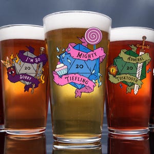 May include: Five pint glasses filled with beer, each featuring a unique design. The designs include a D20 die with phrases like "Mighty Tiefling" and "I'm so sorry". Each glass has a different color scheme and a foamy head.