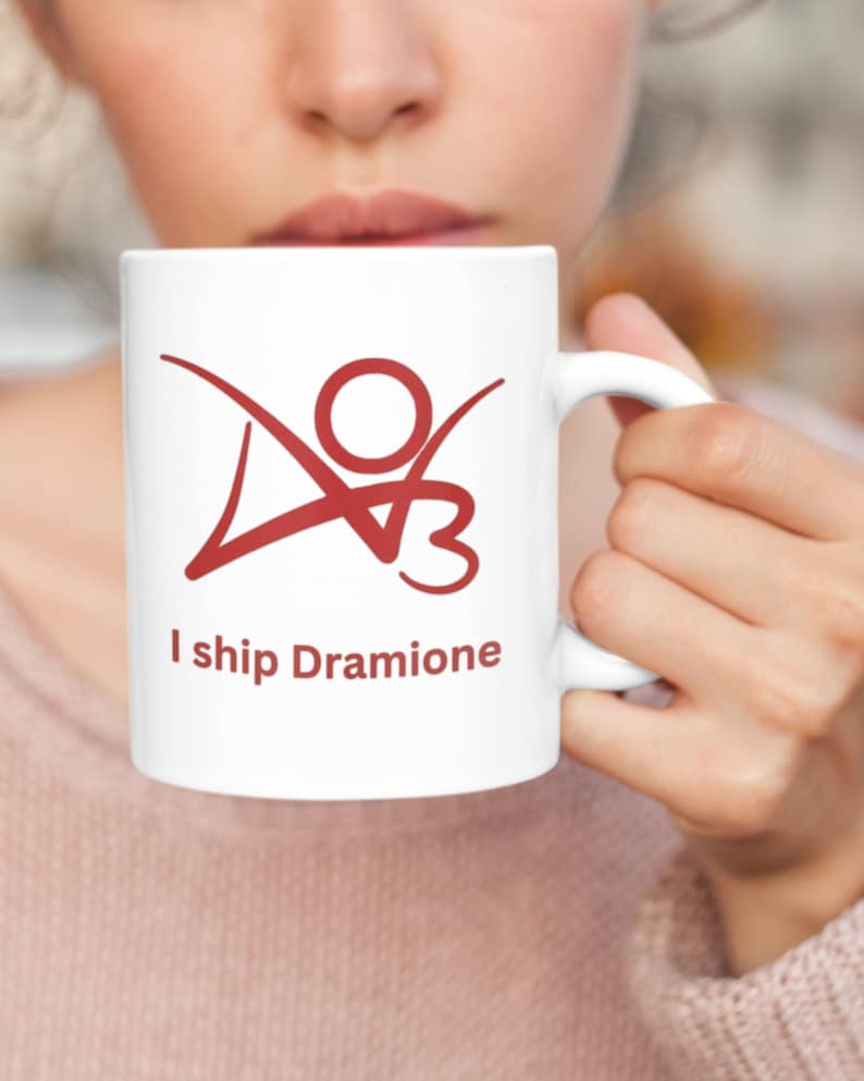 K&ouml;nnte beinhalten: Eine wei&szlig;e Keramiktasse mit einer roten Grafik einer Strichm&auml;nnchenfigur mit dem Text "I ship Dramione".