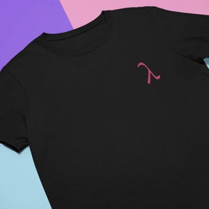 Peut inclure: Un t-shirt noir avec un symbole lambda rose sur le devant.