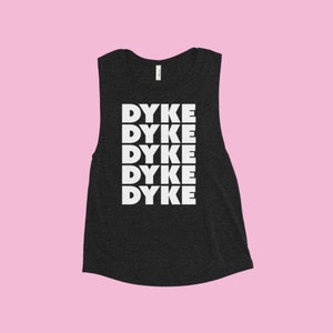 May include: A black sleeveless shirt with the word "DYKE" repeated five times in white letters down the front.